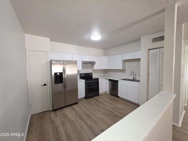 720 S Dobson Rd Unit 24, Mesa, AZ 85202 - kitchen with light wood-type flooring, light countertops, white cabinetry, appliances with stainless steel finishes, and a sink
