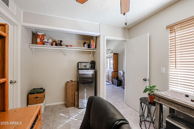 office featuring ceiling fan, light tile patterned floors, and a textured ceiling