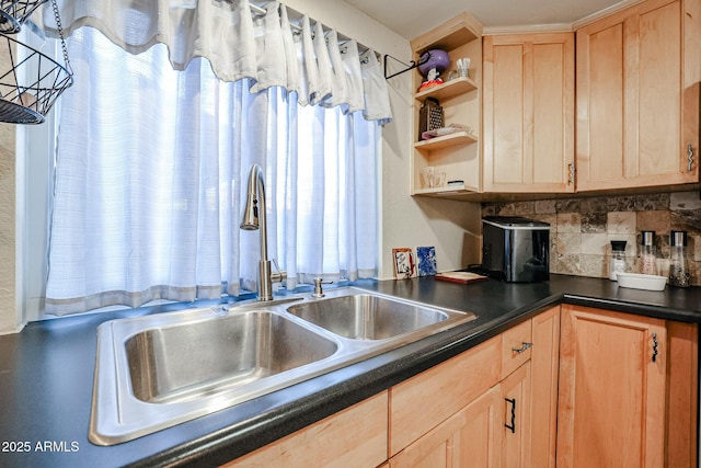 kitchen with light brown cabinetry, sink, and backsplash