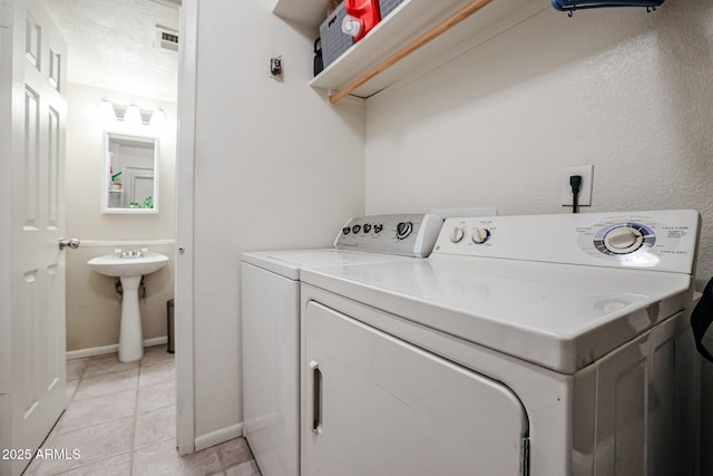 clothes washing area featuring a textured ceiling and washing machine and dryer