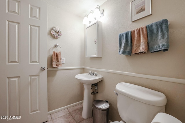 bathroom featuring toilet and tile patterned flooring