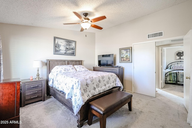 carpeted bedroom with a textured ceiling, ceiling fan, and lofted ceiling