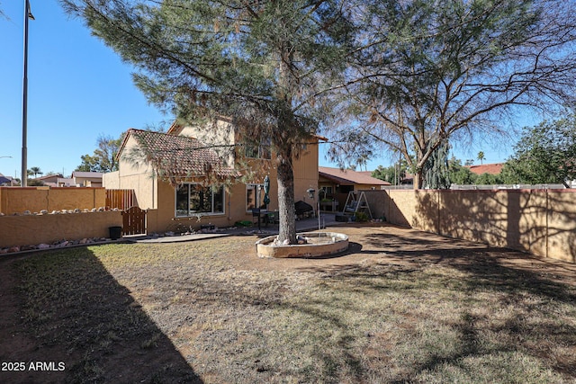 rear view of property featuring a lawn and a patio