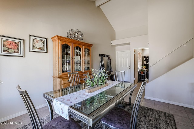 tiled dining area with beamed ceiling and high vaulted ceiling