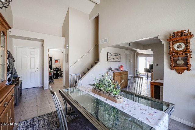 dining room featuring light tile patterned floors and high vaulted ceiling