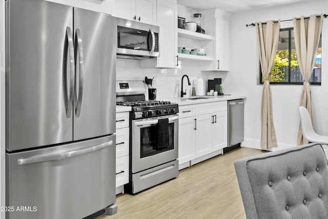 3139 N 40th St, Phoenix, AZ 85018 - kitchen featuring appliances with stainless steel finishes, a sink, open shelves, tasteful backsplash, and light wood-type flooring
