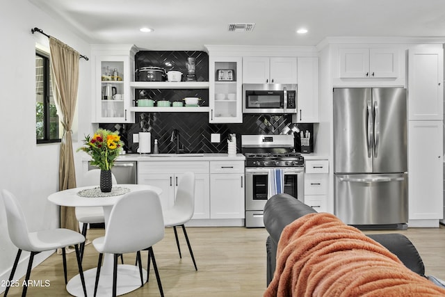 3139 N 40th St, Phoenix, AZ 85018 - kitchen with appliances with stainless steel finishes, a sink, white cabinets, decorative backsplash, and recessed lighting