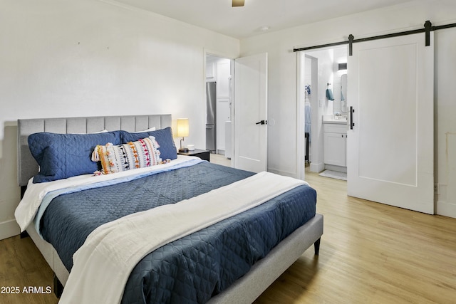 3139 N 40th St, Phoenix, AZ 85018 - bedroom with a barn door, light wood finished floors, and ensuite bath
