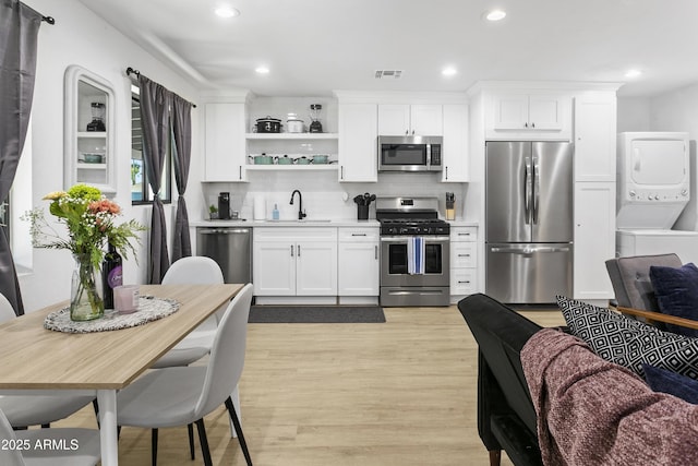 3139 N 40th St, Phoenix, AZ 85018 - kitchen with stainless steel appliances, estacked washer and dryer, a sink, light wood-style floors, and recessed lighting