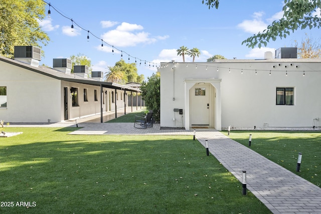 3139 N 40th St, Phoenix, AZ 85018 - entrance to property featuring central air condition unit, a lawn, stucco siding, and a patio