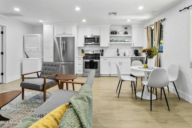 3139 N 40th St, Phoenix, AZ 85018 - kitchen featuring appliances with stainless steel finishes, stacked washer and clothes dryer, a sink, baseboards, and recessed lighting