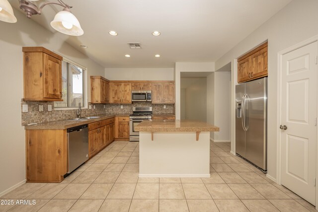 40808 N Raleigh Ct, Anthem, AZ 85086 - kitchen featuring appliances with stainless steel finishes, tasteful backsplash, light tile patterned flooring, a sink, and tile counters