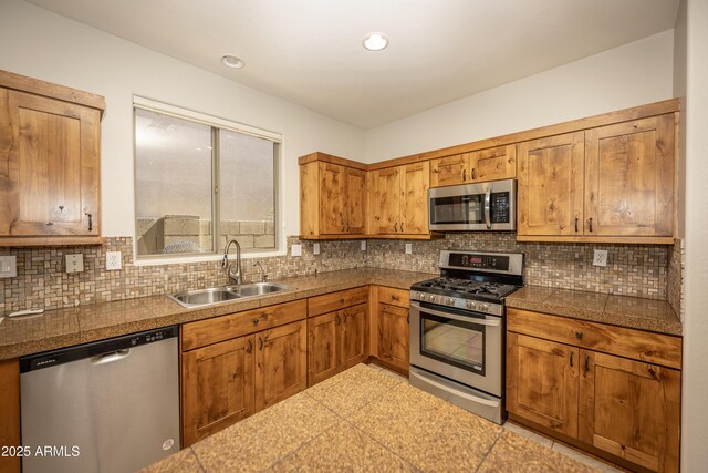 40808 N Raleigh Ct, Anthem, AZ 85086 - kitchen featuring appliances with stainless steel finishes, a sink, tile countertops, brown cabinetry, and recessed lighting