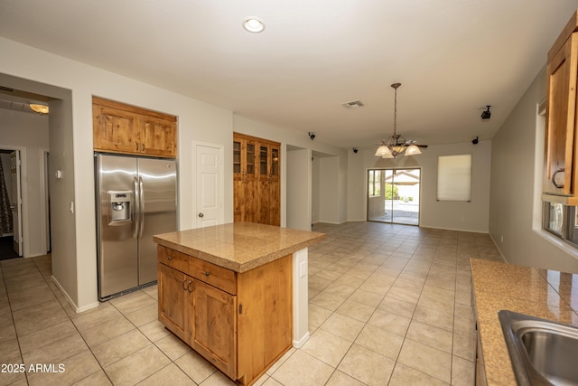 40808 N Raleigh Ct, Anthem, AZ 85086 - kitchen featuring stainless steel fridge with ice dispenser, tile counters, light tile patterned flooring, a sink, and a kitchen island