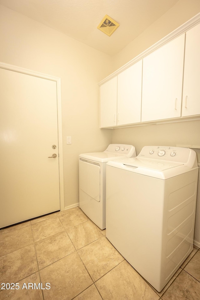 40808 N Raleigh Ct, Anthem, AZ 85086 - washroom featuring cabinet space, independent washer and dryer, light tile patterned floors, and baseboards
