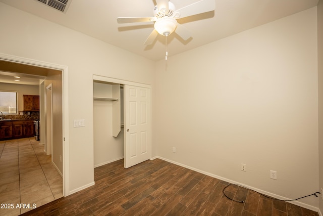 40808 N Raleigh Ct, Anthem, AZ 85086 - unfurnished bedroom featuring wood finished floors, a closet, baseboards, ceiling fan, and a sink
