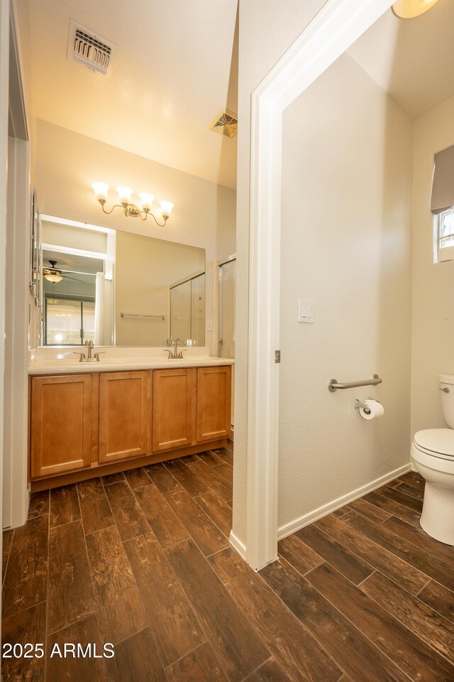 40808 N Raleigh Ct, Anthem, AZ 85086 - bathroom featuring wood finished floors, toilet, double vanity, and ceiling fan