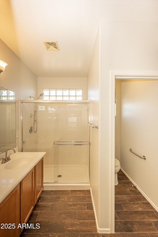 40808 N Raleigh Ct, Anthem, AZ 85086 - bathroom featuring wood finished floors, a shower stall, toilet, and vanity