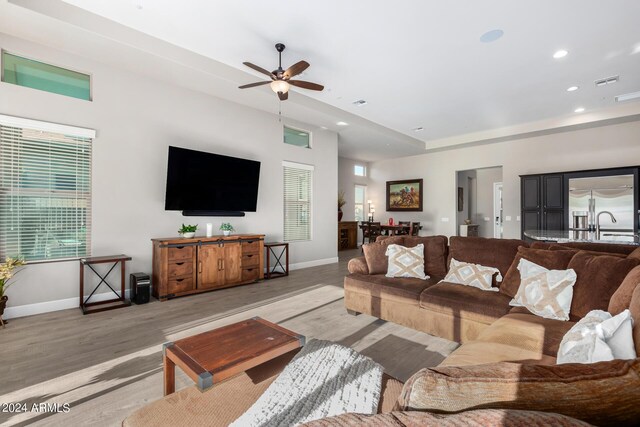 living room with ceiling fan and light hardwood / wood-style flooring