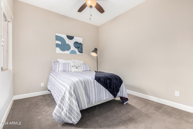 carpeted bedroom with ceiling fan and vaulted ceiling