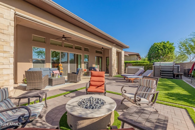 view of patio with ceiling fan, an outdoor hangout area, and a hot tub