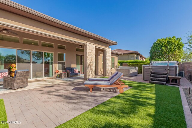 view of patio / terrace with a hot tub and ceiling fan