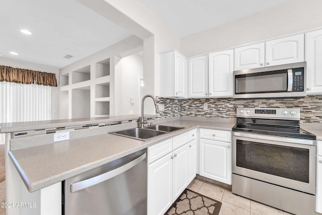 kitchen with kitchen peninsula, sink, stainless steel appliances, and white cabinets