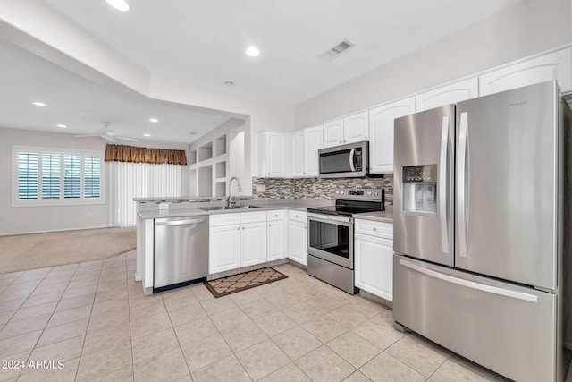 kitchen with white cabinets, appliances with stainless steel finishes, sink, and kitchen peninsula