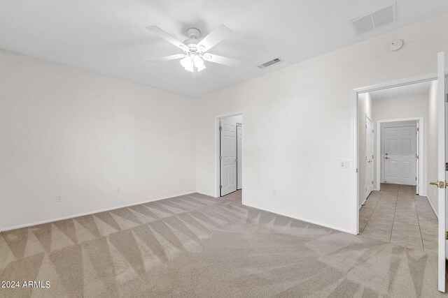 unfurnished room featuring ceiling fan and light colored carpet