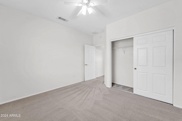 unfurnished bedroom featuring ceiling fan, a closet, and light carpet