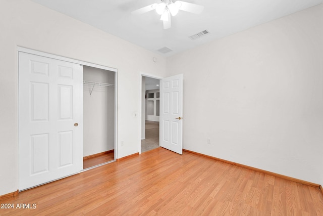 unfurnished bedroom featuring ceiling fan, light wood-type flooring, and a closet