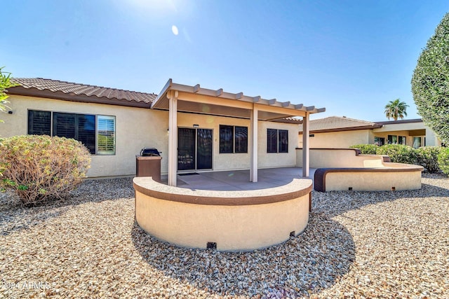 rear view of house featuring a pergola and a patio