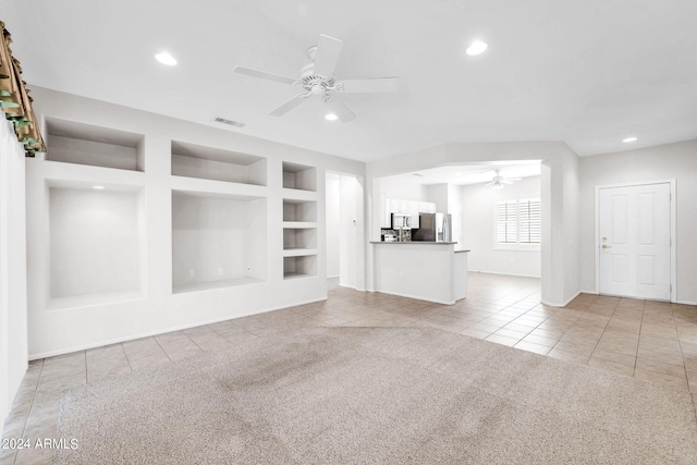 unfurnished living room with light carpet, ceiling fan, and built in features