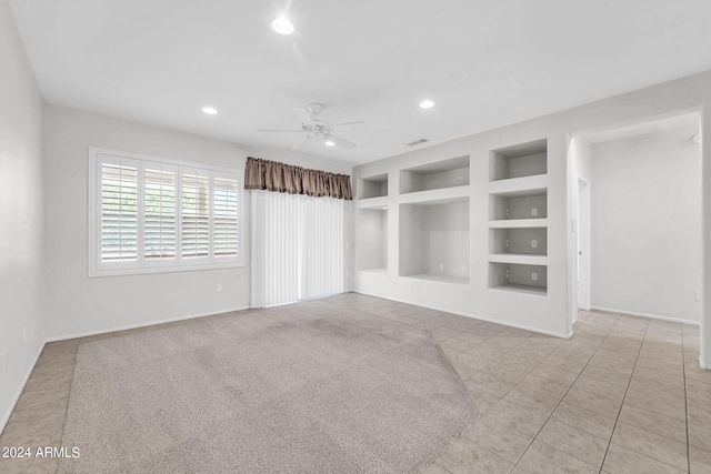 tiled spare room featuring ceiling fan and built in features