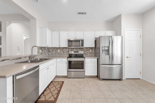 kitchen with decorative backsplash, stainless steel appliances, white cabinetry, and sink