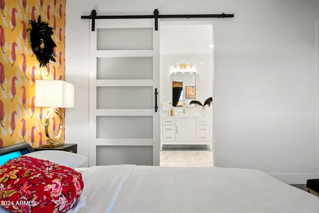 bedroom with ensuite bathroom and a barn door