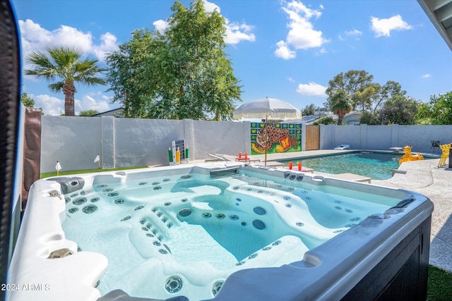 view of swimming pool with a hot tub