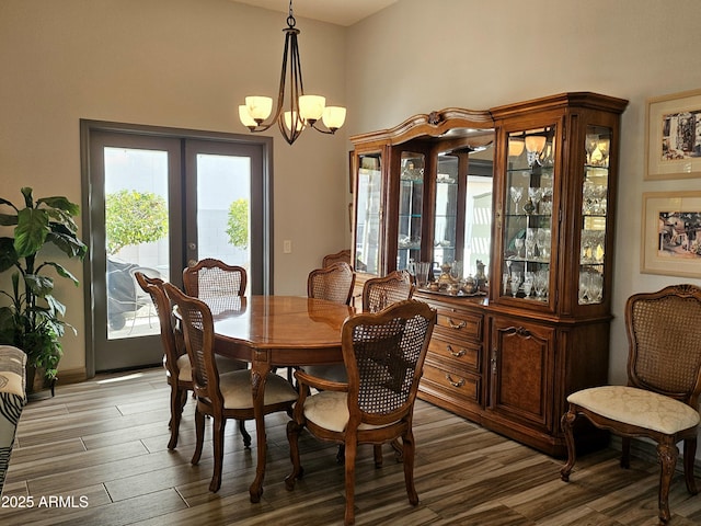 dining area with hardwood / wood-style flooring, french doors, and a chandelier