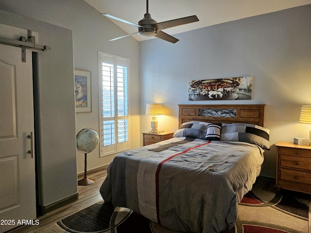 bedroom featuring hardwood / wood-style flooring, ceiling fan, and lofted ceiling