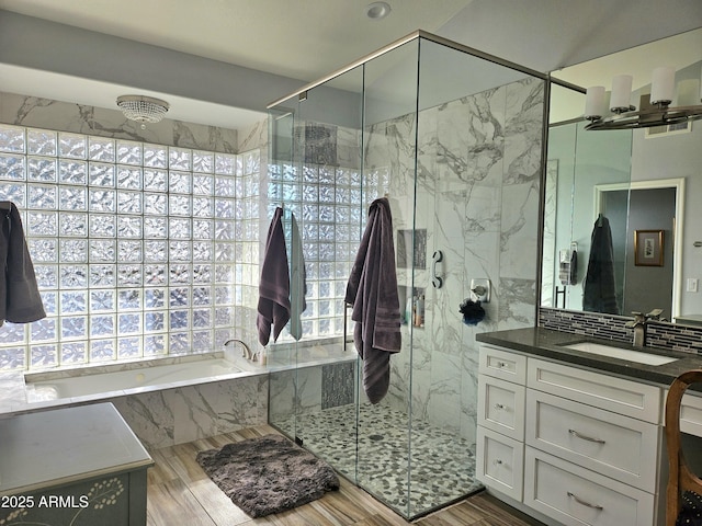 bathroom featuring shower with separate bathtub, vanity, a healthy amount of sunlight, and wood-type flooring