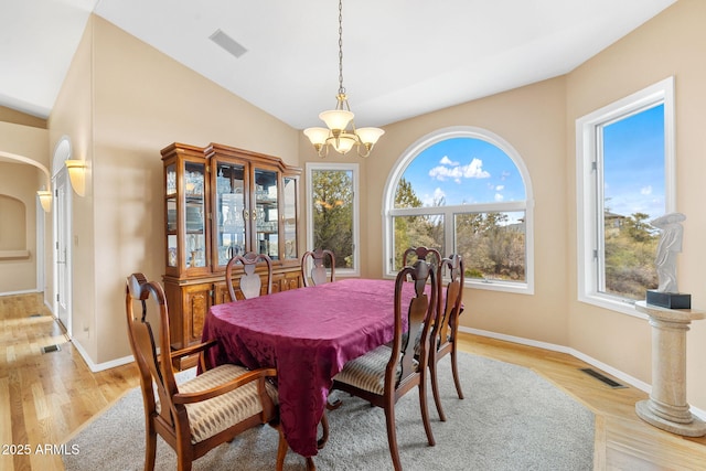 dining area with visible vents, an inviting chandelier, and lofted ceiling