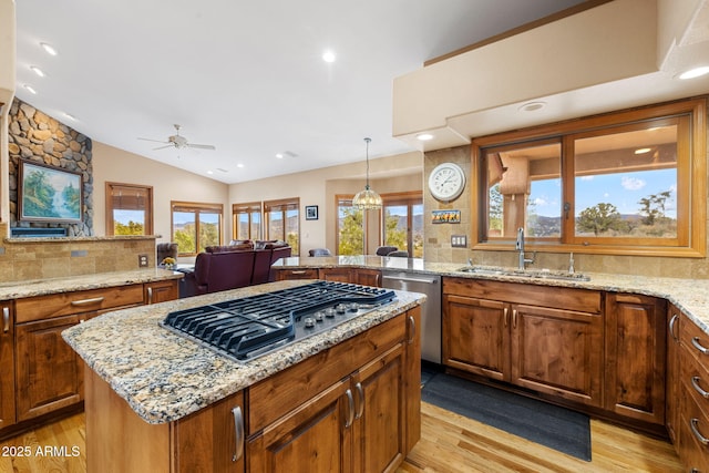 kitchen with a sink, stainless steel appliances, backsplash, and ceiling fan