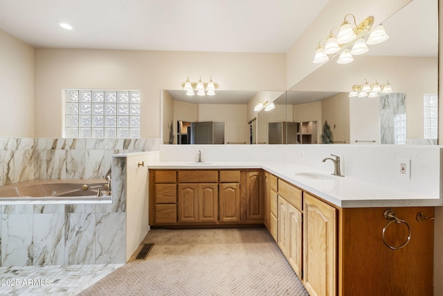 full bathroom with double vanity, visible vents, a bath, and a sink