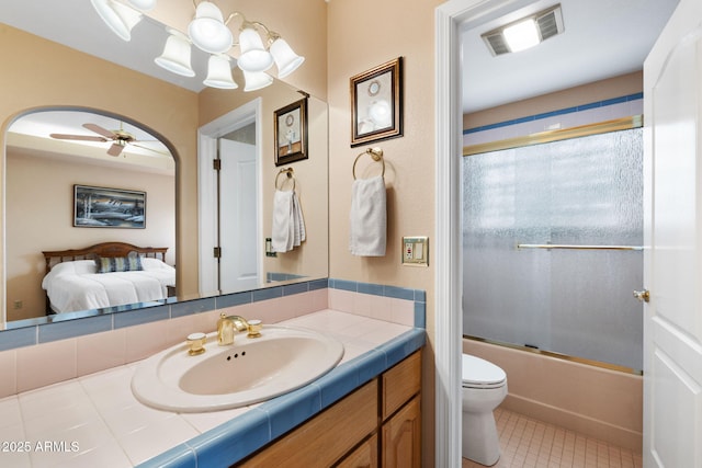 ensuite bathroom with visible vents, toilet, ensuite bath, shower / bath combination with glass door, and vanity