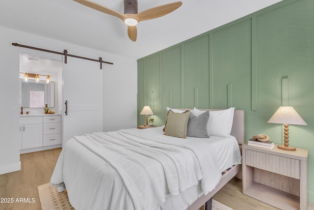 15435 N 28th St Unit 3, Phoenix, AZ 85032 - bedroom featuring a barn door, light wood-style floors, a ceiling fan, and ensuite bath