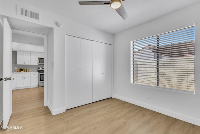 15435 N 28th St Unit 3, Phoenix, AZ 85032 - unfurnished bedroom with light wood-style floors, baseboards, a closet, and a ceiling fan