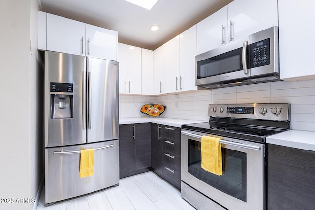 14300 W Bell Rd Unit 222, Surprise, AZ 85374 - kitchen featuring stainless steel appliances, light countertops, white cabinets, and backsplash