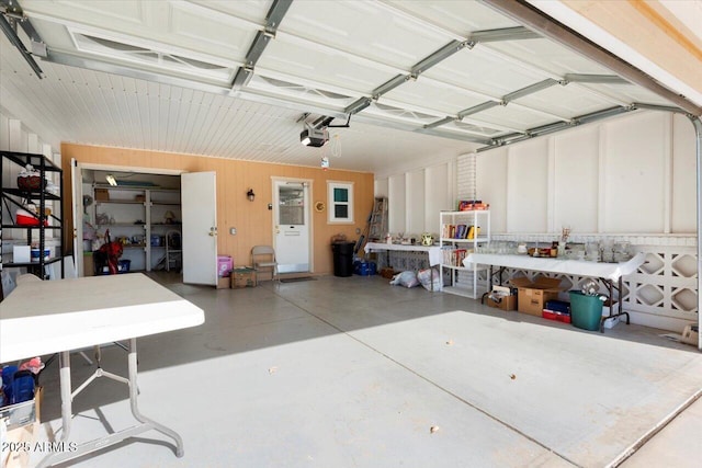 garage with a workshop area and wooden walls