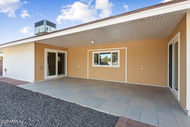 rear view of property with central air condition unit and a patio area