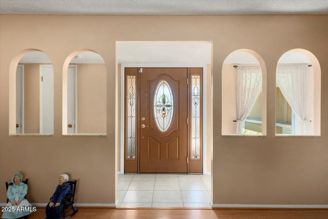 tiled entrance foyer with a healthy amount of sunlight and a textured ceiling